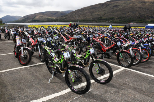 the-iconic-scene-of-280-trials-bikes-gathered-in-the-fort-william-west-end-car-park-parc-ferme-after-sundays-technical-control